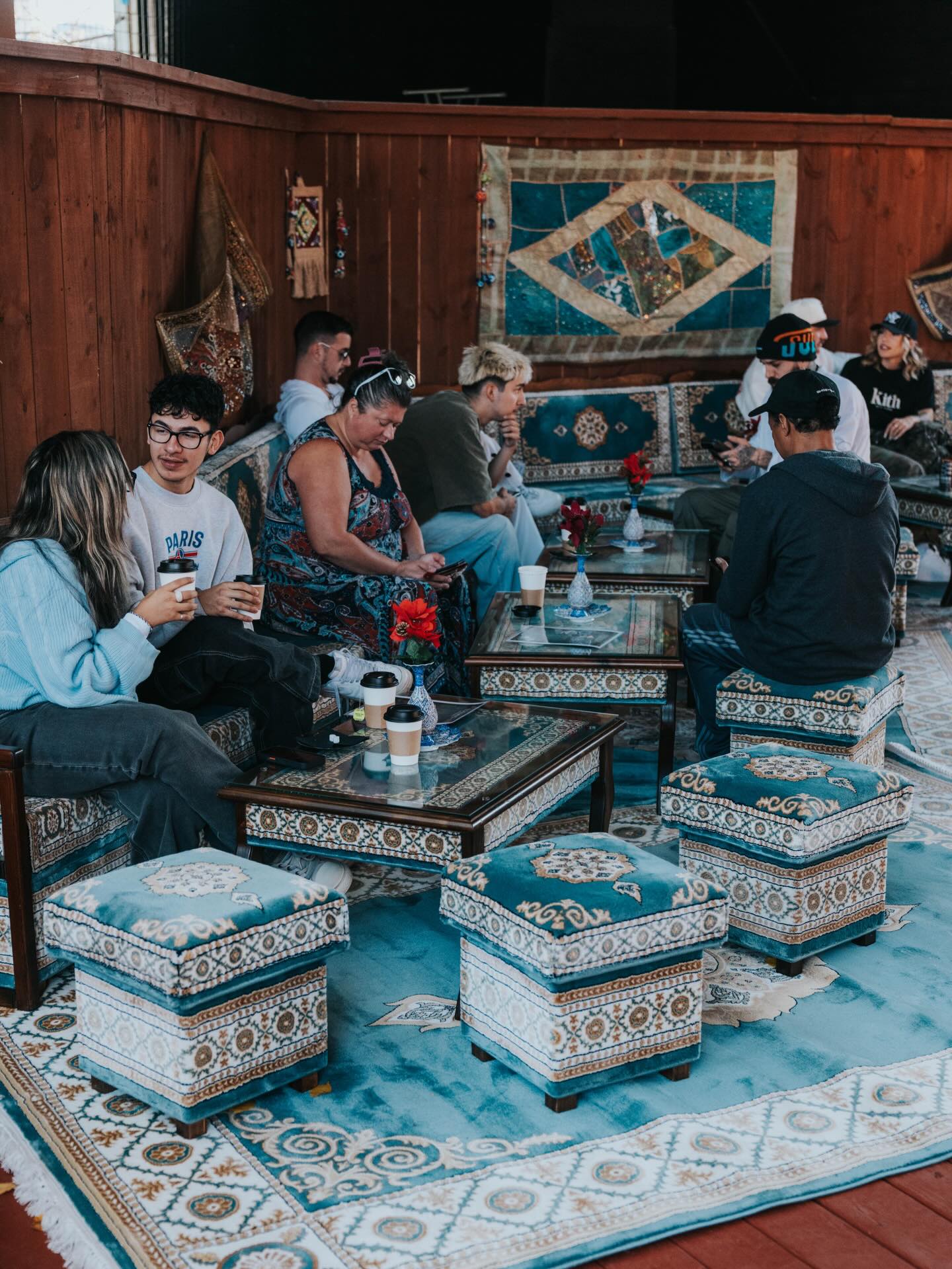 Friends gathered on traditional majlis floor seating with kilim rugs at Sip Haus Austin